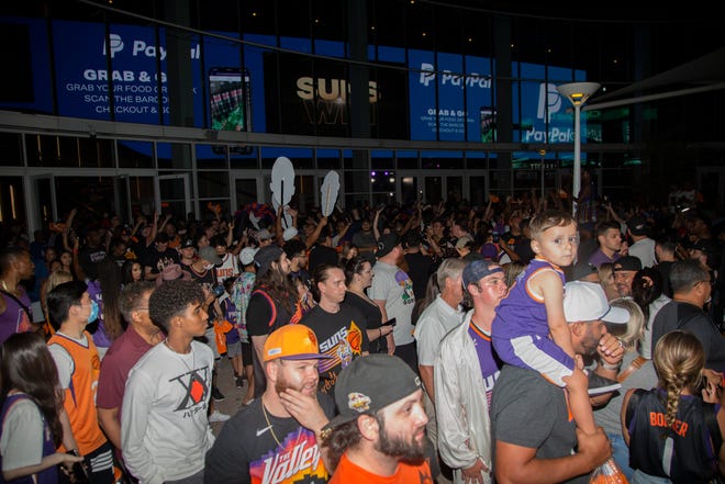 Suns fans celebrate after their team beat the Milwaukee Bucks 118-108 in Game 2 of the NBA Finals outside the Phoenix Suns Arena in Phoenix on July 8, 2021.