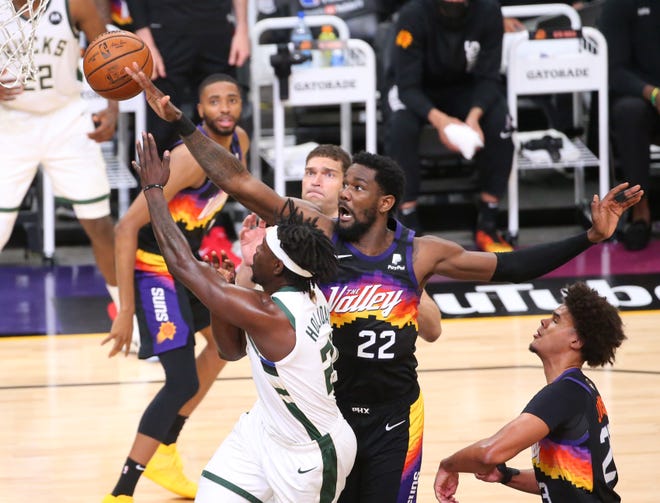 Phoenix Suns center Deandre Ayton (22) blocks a shot by Milwaukee Bucks guard Jrue Holiday (21) during Game 2 of the NBA Finals at Phoenix Suns Arena July 8, 2021.