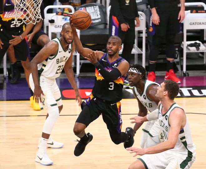 Phoenix Suns guard Chris Paul (3) drives past Milwaukee Bucks forward Khris Middleton (22), guard Jrue Holiday (21) and center Brook Lopez (11) during Game 2 of the NBA Finals at Phoenix Suns Arena July 8, 2021.