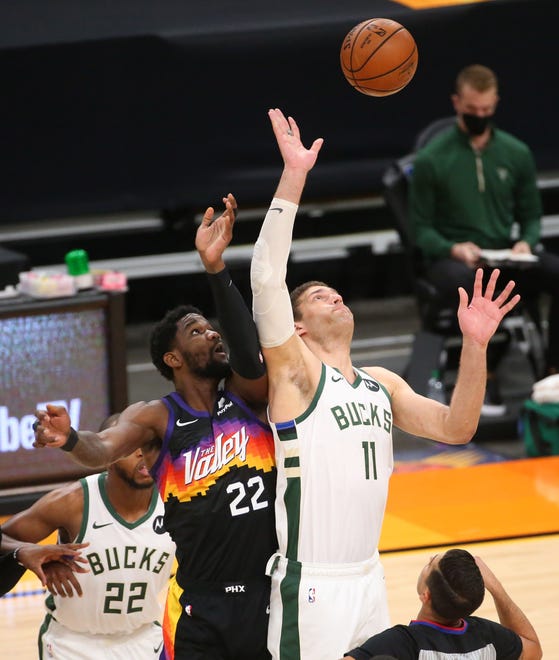 Phoenix Suns center Deandre Ayton (22) jumps center with Milwaukee Bucks center Brook Lopez (11) during Game 2 of the NBA Finals at Phoenix Suns Arena July 8, 2021.