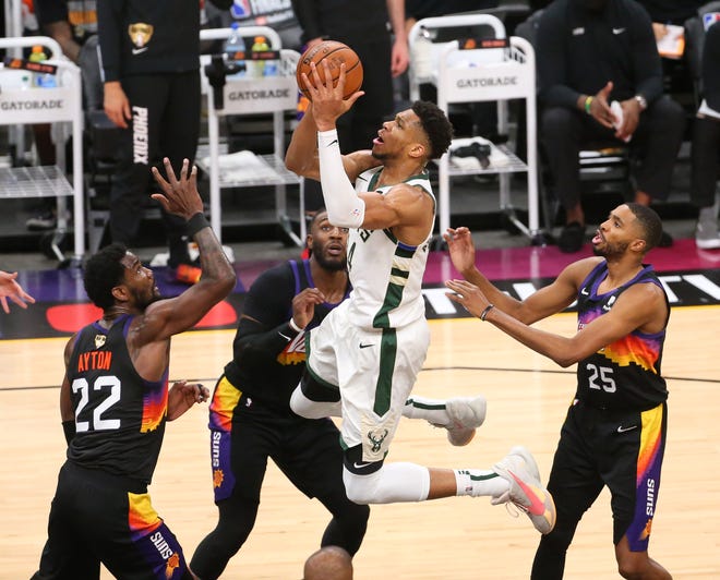Milwaukee Bucks forward Giannis Antetokounmpo (34) puts a shot up against Phoenix Suns center Deandre Ayton (22) during Game 2 of the NBA Finals at Phoenix Suns Arena July 8, 2021.