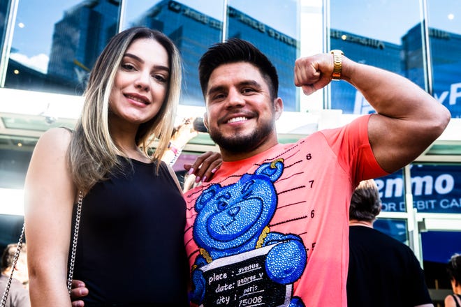 The "Triple Champ" Henry Cejudo and Ana Karolina pose at the Phoenix Suns Arena for Game 2 of the NBA finals vs. the Milwaukee Bucks on July 8, 2021.