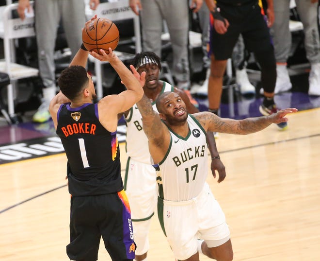 Phoenix Suns guard Devin Booker (1) shots against Milwaukee Bucks forward P.J. Tucker (17) during Game 2 of the NBA Finals at Phoenix Suns Arena July 8, 2021.