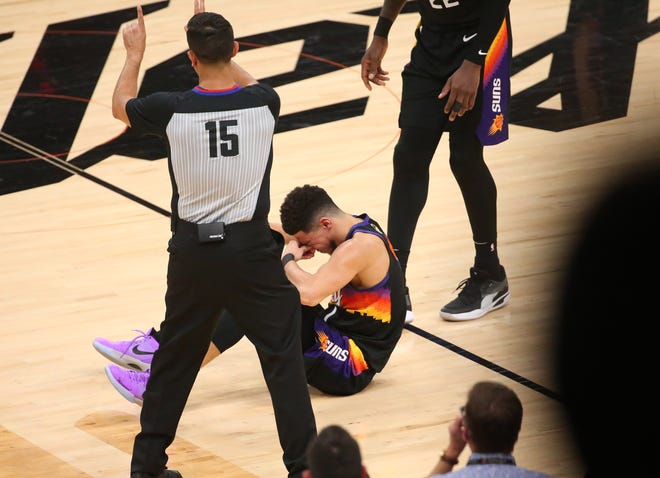 Phoenix Suns guard Devin Booker (1) sits on the floor after a foul by the Milwaukee Bucks during Game 2 of the NBA Finals at Phoenix Suns Arena July 8, 2021.