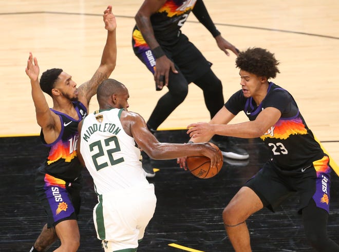 Phoenix Suns forward Cameron Johnson (23) strips the ball from Milwaukee Bucks forward Khris Middleton (22) during Game 2 of the NBA Finals at Phoenix Suns Arena July 8, 2021.