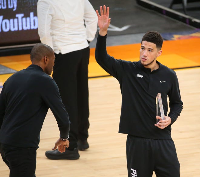Phoenix Suns guard Devin Booker waves after receiving the season-long Community Assist award before Game 2 of the NBA Finals against the Milwaukee Bucks at Phoenix Suns Arena July 8, 2021.