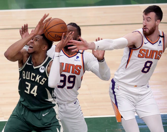 Giannis Antetokounmpo, de los Bucks de Milwaukee, trata de eludir la defensiva de Suns.