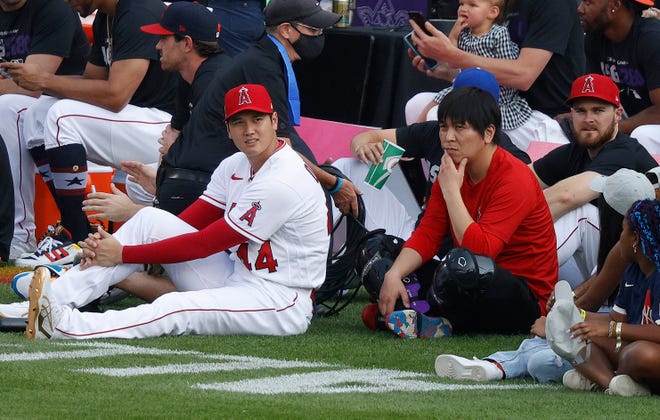 Shohei Ohtani and his interpreter Ippei Mizuhara watch from the sidelines.