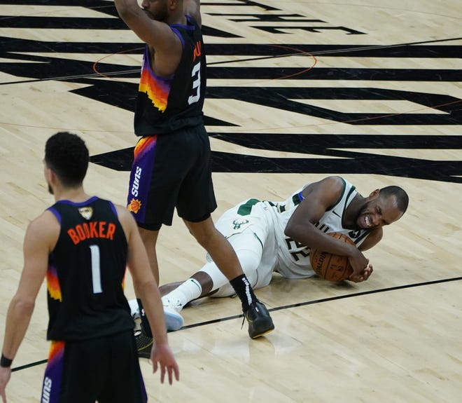 Milwaukee Bucks forward Khris Middleton (22) lays on the floor temporarily after getting fouled during the third quarter of Game 5 of the NBA Finals at Footprint Center in Phoenix on Saturday.
