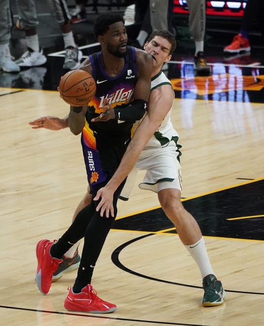 Milwaukee Bucks center Brook Lopez (11) defends against Phoenix Suns center Deandre Ayton (22) during the second quarter of Game 5 of the NBA Finals at Footprint Center in Phoenix on Saturday.