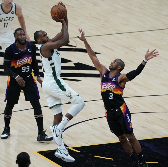 Milwaukee Bucks forward Khris Middleton (22) hits a jump shot as Phoenix Suns guard Chris Paul (3) defends during the third quarter of Game 5 of the NBA Finals at Footprint Center in Phoenix on Saturday.