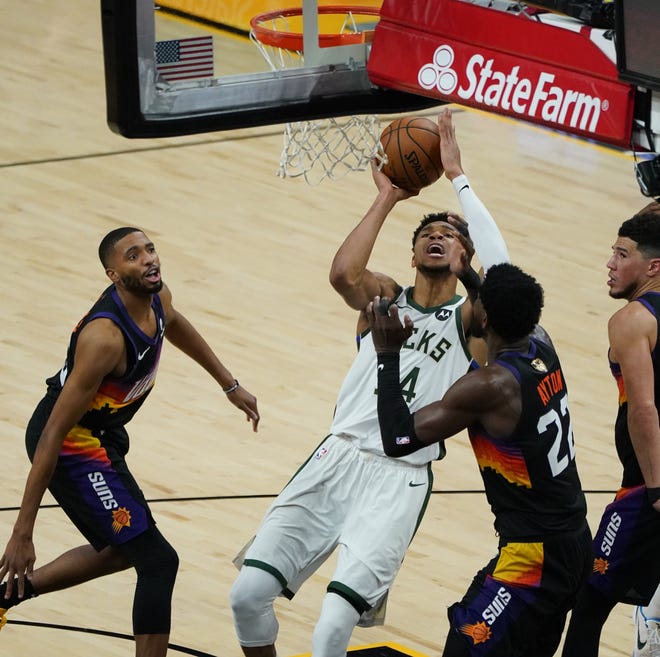 Milwaukee Bucks forward Giannis Antetokounmpo (34) shoots over Phoenix Suns center Deandre Ayton (22) during the fourth quarter of Game 5 of Bucks 123-119 win over the Phoenix Suns in the NBA Finals at Footprint Center in Phoenix on Saturday.
