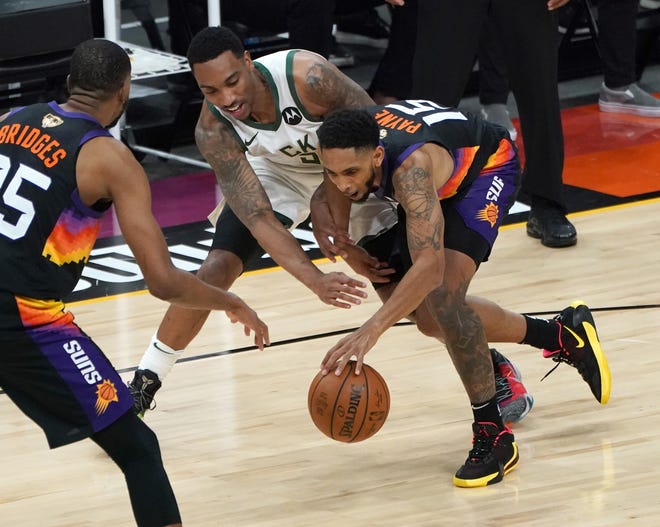 Milwaukee Bucks guard Jeff Teague (5) loses the ball stolen by Phoenix Suns guard Cameron Payne (15) during the first quarter of Game 5 of the NBA Finals at Footprint Center in Phoenix on Saturday.