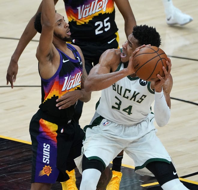 Milwaukee Bucks forward Giannis Antetokounmpo (34) truest find a shot defended by Phoenix Suns guard Cameron Payne (15) during the first quarter of Game 5 of the NBA Finals at Footprint Center in Phoenix on Saturday.