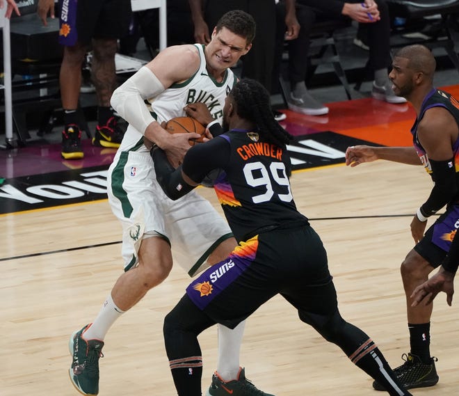 Milwaukee Bucks center Brook Lopez (11) and Phoenix Suns forward Jae Crowder (99) fight for a rebound during the first quarter of Game 5 of the NBA Finals at Footprint Center in Phoenix on Saturday.