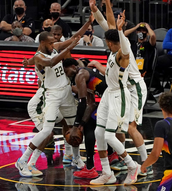 Phoenix Suns center Deandre Ayton (22) tries to get away with the ball surrounded by a group of Milwaukee Bucks including Milwaukee Bucks forward Khris Middleton (22) and Milwaukee Bucks forward Giannis Antetokounmpo (34) during the second quarter of Game 5 of the NBA Finals at Footprint Center in Phoenix on Saturday.