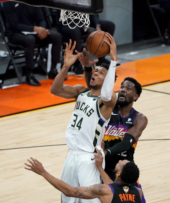 Milwaukee Bucks forward Giannis Antetokounmpo (34) puts up a shot defended by Phoenix Suns center Deandre Ayton (22) during the third quarter of Game 5 of the NBA Finals at Footprint Center in Phoenix on Saturday.