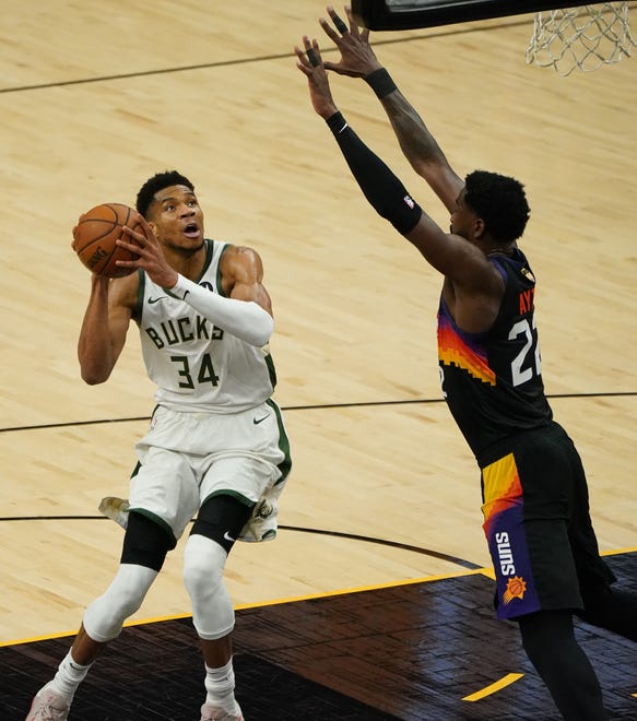 Milwaukee Bucks forward Giannis Antetokounmpo (34) looks to shoot guarded by Phoenix Suns center Deandre Ayton (22) during the third quarter of Game 5 of the NBA Finals at Footprint Center in Phoenix on Saturday.