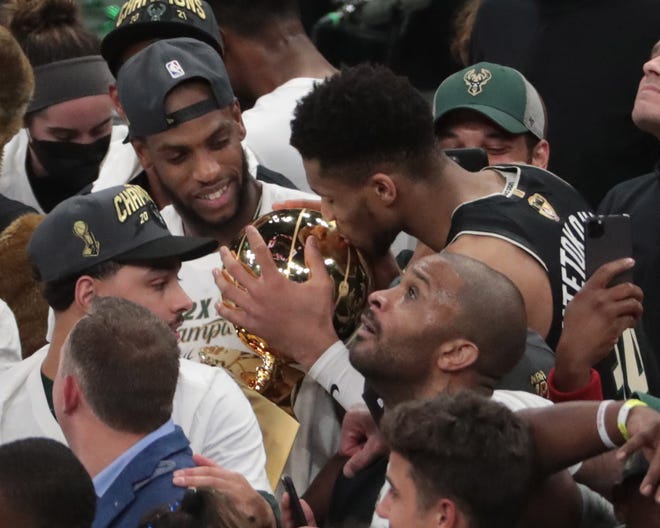 Milwaukee Bucks forward Giannis Antetokounmpo (34) kisses the Larry O'Brien Championship Trophy after beating the Phoenix Suns in Game 6 of the NBA Finals at Fiserv Forum July 20, 2021.