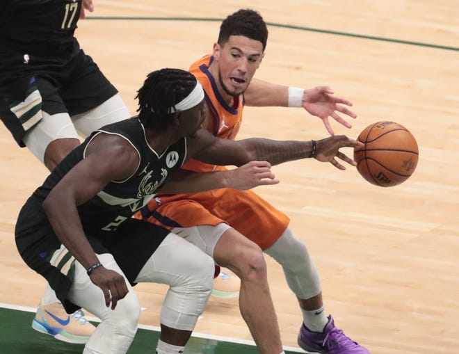 Phoenix Suns guard Devin Booker (1) has the ball deflected away by Milwaukee Bucks guard Jrue Holiday (21) during Game 6 of the NBA Finals at Fiserv Forum July 20, 2021.