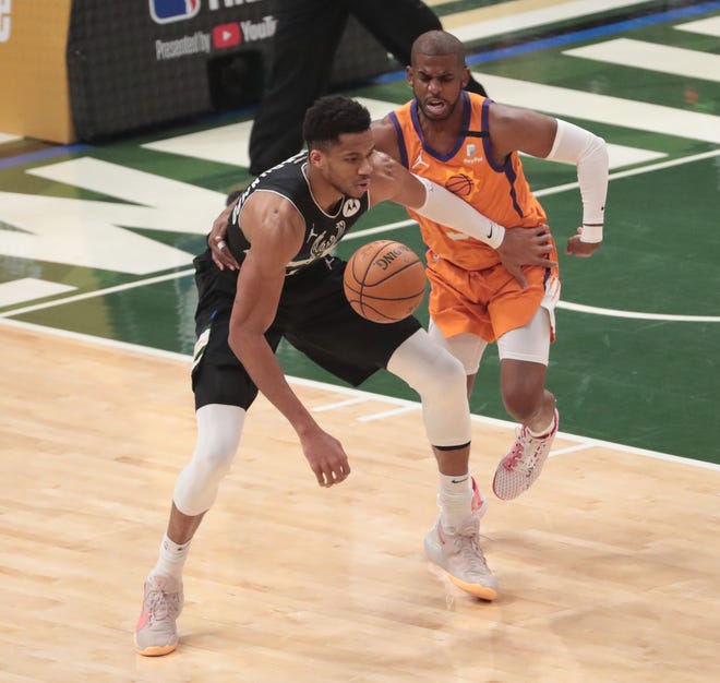Milwaukee Bucks forward Giannis Antetokounmpo (34) is defended by Phoenix Suns guard Chris Paul (3) during Game 6 of the NBA Finals at Fiserv Forum July 20, 2021.