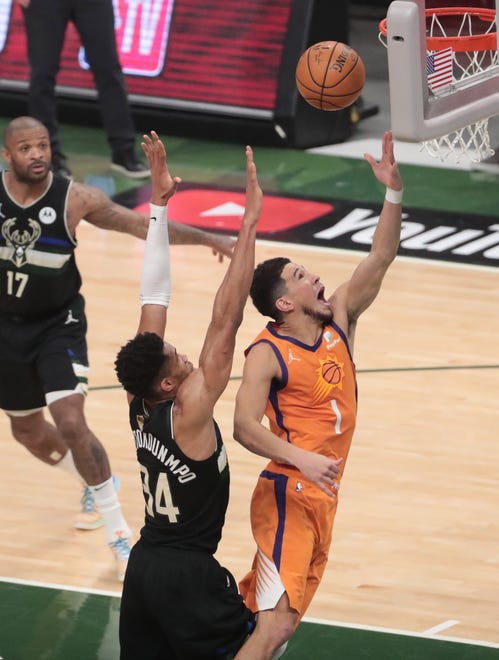 Phoenix Suns guard Devin Booker (1) lays the ball in against Milwaukee Bucks forward Giannis Antetokounmpo (34) during Game 6 of the NBA Finals at Fiserv Forum July 20, 2021.