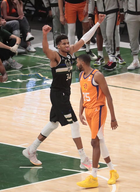 Milwaukee Bucks forward Giannis Antetokounmpo (34)  celebrates in front of Phoenix Suns forward Mikal Bridges (25) after winning Game 6 of the NBA Finals at Fiserv Forum July 20, 2021.
