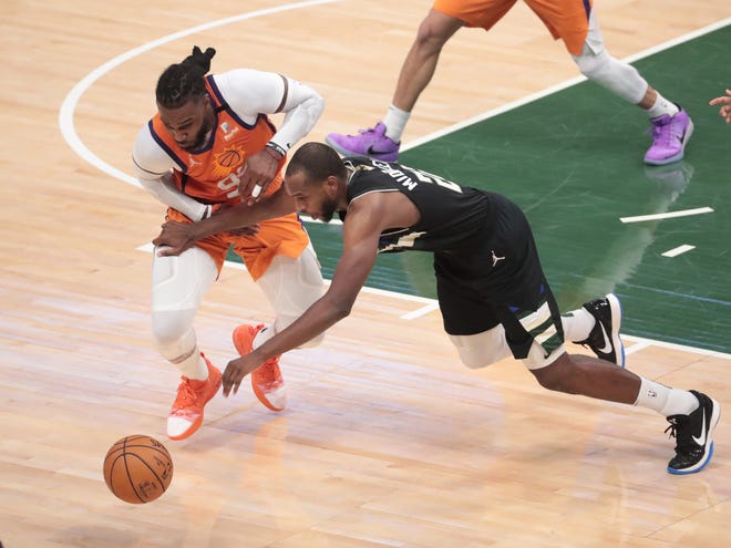 Milwaukee Bucks forward Khris Middleton (22) has the ball deflected away by Phoenix Suns forward Jae Crowder (99) during Game 6 of the NBA Finals at Fiserv Forum July 20, 2021.