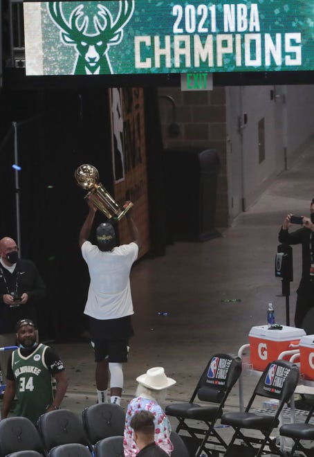 Milwaukee Bucks forward Khris Middleton (22) holds the Larry O'Brien Championship Trophy after beating the Phoenix Suns in Game 6 of the NBA Finals at Fiserv Forum July 20, 2021.