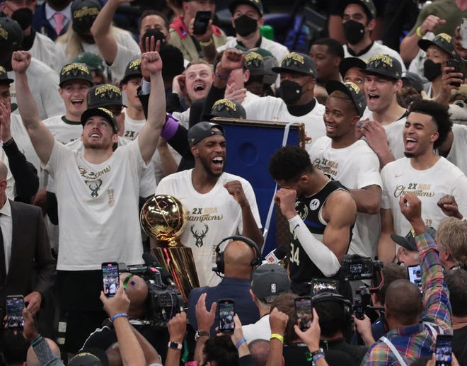 Milwaukee Bucks players celebrate with the Larry O'Brien Championship Trophy after beating the Phoenix Suns in Game 6 of the NBA Finals at Fiserv Forum July 20, 2021.