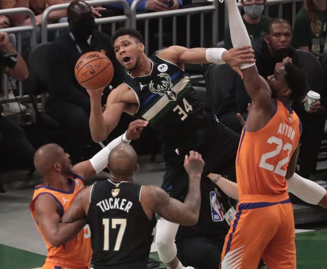 Milwaukee Bucks forward Giannis Antetokounmpo (34) looks to pass against Phoenix Suns center Deandre Ayton (22) during Game 6 of the NBA Finals at Fiserv Forum July 20, 2021.
