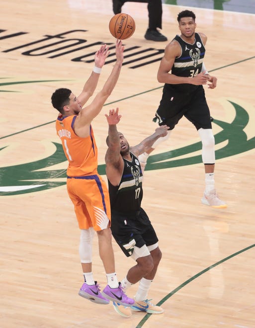 Phoenix Suns guard Devin Booker (1) shoots over Milwaukee Bucks forward P.J. Tucker (17) during Game 6 of the NBA Finals at Fiserv Forum July 20, 2021.