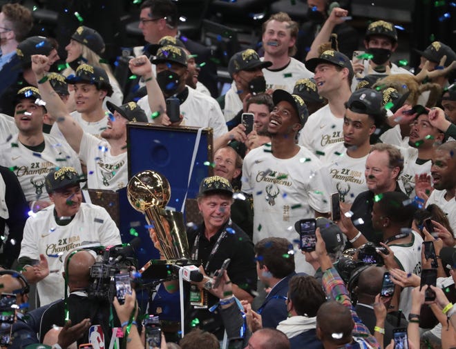 Milwaukee Bucks head coach Mike Budenholzer and his players celebrate with the Larry O'Brien Championship Trophy after beating the Phoenix Suns in Game 6 of the NBA Finals at Fiserv Forum July 20, 2021.