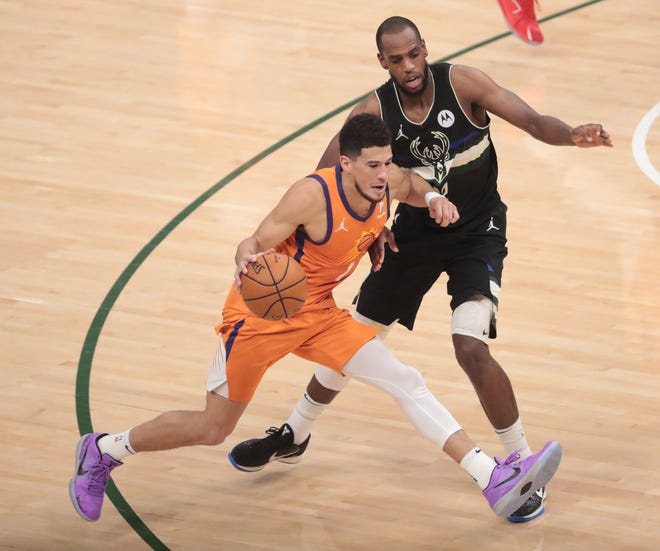 Phoenix Suns guard Devin Booker (1) is defended by Milwaukee Bucks forward Khris Middleton (22) during Game 6 of the NBA Finals at Fiserv Forum July 20, 2021.