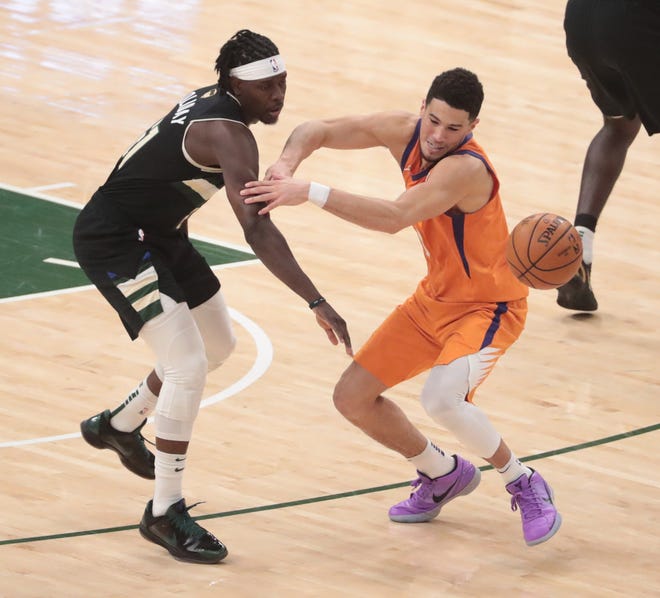 Phoenix Suns guard Devin Booker (1) has the ball deflected away by Milwaukee Bucks guard Jrue Holiday (21) during Game 6 of the NBA Finals at Fiserv Forum July 20, 2021.