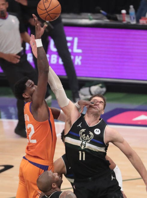 Phoenix Suns center Deandre Ayton (22) shoots against Milwaukee Bucks center Brook Lopez (11) during Game 6 of the NBA Finals at Fiserv Forum July 20, 2021.