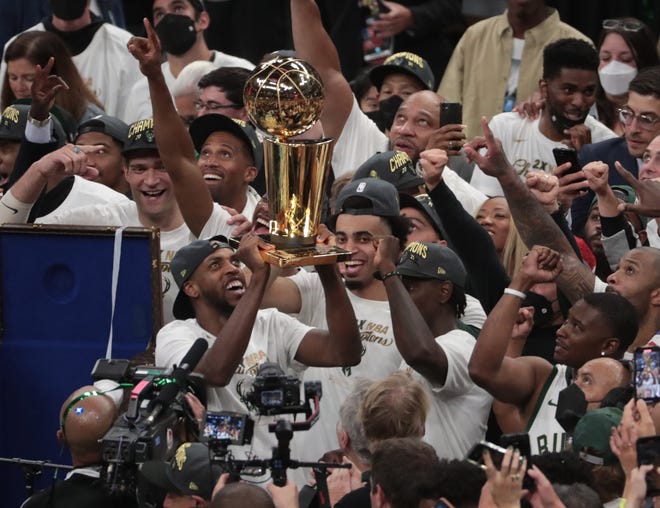 Milwaukee Bucks forward Khris Middleton (22) holds the Larry O'Brien Championship Trophy after beating the Phoenix Suns in Game 6 of the NBA Finals at Fiserv Forum July 20, 2021.