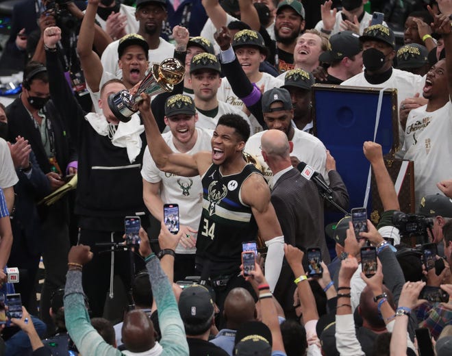Milwaukee Bucks forward Giannis Antetokounmpo (34) holds the MVP trophy after beating the Phoenix Suns in Game 6 of the NBA Finals at Fiserv Forum July 20, 2021.