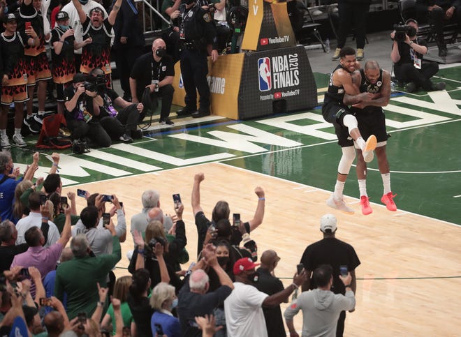 Milwaukee Bucks forward Giannis Antetokounmpo (34) celebrates with Milwaukee Bucks forward P.J. Tucker (17) in the final seconds of Game 6 of the NBA Finals against the Phoenix Suns at Fiserv Forum July 20, 2021.