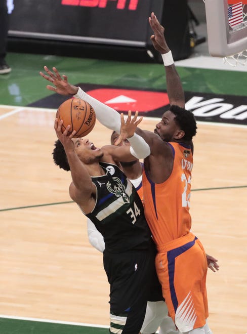 Milwaukee Bucks forward Giannis Antetokounmpo (34) is fouled by Phoenix Suns center Deandre Ayton (22) during Game 6 of the NBA Finals at Fiserv Forum July 20, 2021.