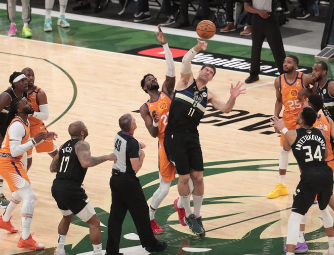 Phoenix Suns center Deandre Ayton (22) jumps center with Milwaukee Bucks center Brook Lopez (11) during Game 6 of the NBA Finals at Fiserv Forum July 20, 2021.