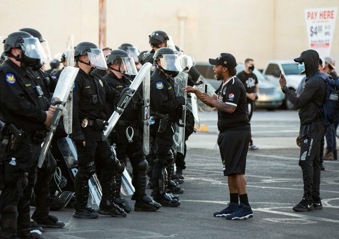 Protester Robert Dossie expresses his feeling to the Phoenix Police officers in response to George Floyd, who died in police custody on May 25, 2020, in Minneapolis, Phoenix, June 1, 2020.