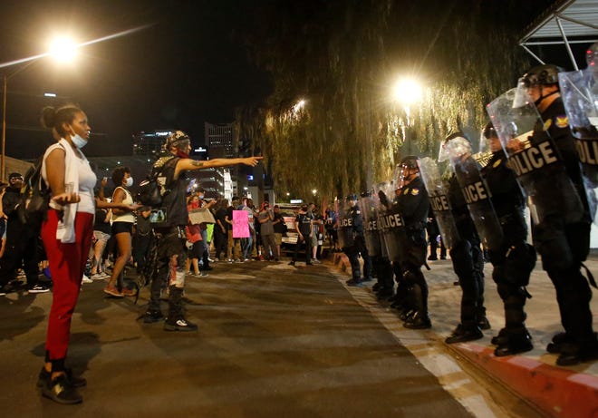 Protesters stand off with police outside the Phoenix Police Headquarters during a protest in Phoenix on May 30, 2020.
