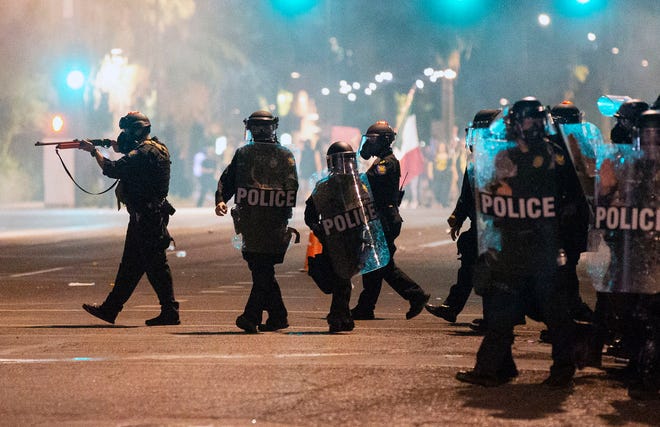 Phoenix Police in riot gear break-up protesters outside police headquarters during a rally and march in Phoenix on May 29, 2020, to remember Dion Johnson who was shot and killed during a struggle with a DPS trooper on May 25.