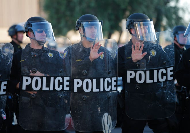 Phoenix Police officers brace themselves as protesters march towards them in downtown Phoenix on June 1, 2020. People have been demonstrating for George Floyd, killed by police in Minnesota, and Dion Johnson, shot by an Arizona Department of Public Safety officer in Phoenix.