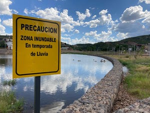 A sign in El Represo de Nogales, a rehabilitated $5 million dam and recreational park in the border city, warns about flood risks. Nogales, Sonora. Aug. 27, 2021.
