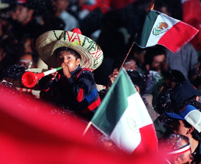 Un niño toca la corneta en la celebración de la independencia de México.