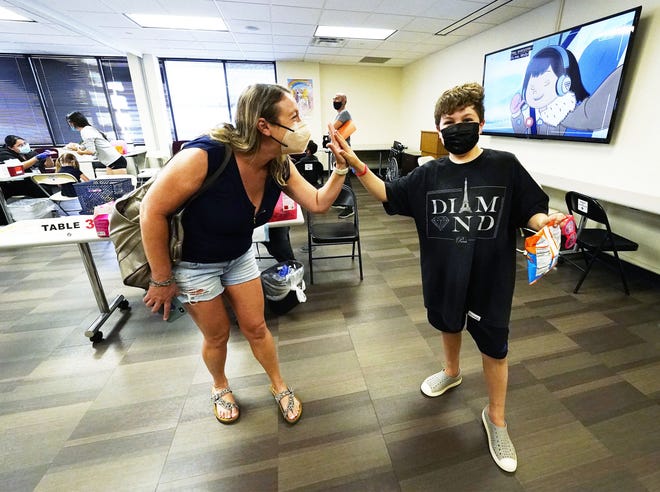 Marisa O'Connor high-fives her 8-year-old son Jonas O'Connor after he received his COVID-19 vaccine at Native Health Central clinic in Phoenix on Nov. 5, 2021.