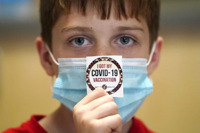 Logan Hute, 9, shows off his sticker after receiving his COVID-19 vaccine at Native Health Central clinic in Phoenix on Nov. 5, 2021.