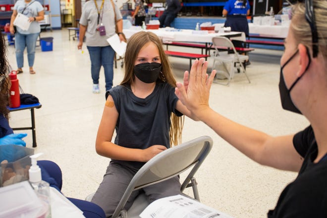 Ellie Murray, 9, high fives her mom, Samantha Murray, after receiving her COVID-19 vaccination at John F. Long Elementary in Phoenix, Ariz. on Nov. 5, 2021.